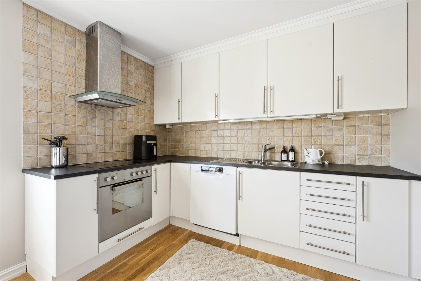 Kjøkkenet har slette fronter og laminat benkeplate Galleribilde