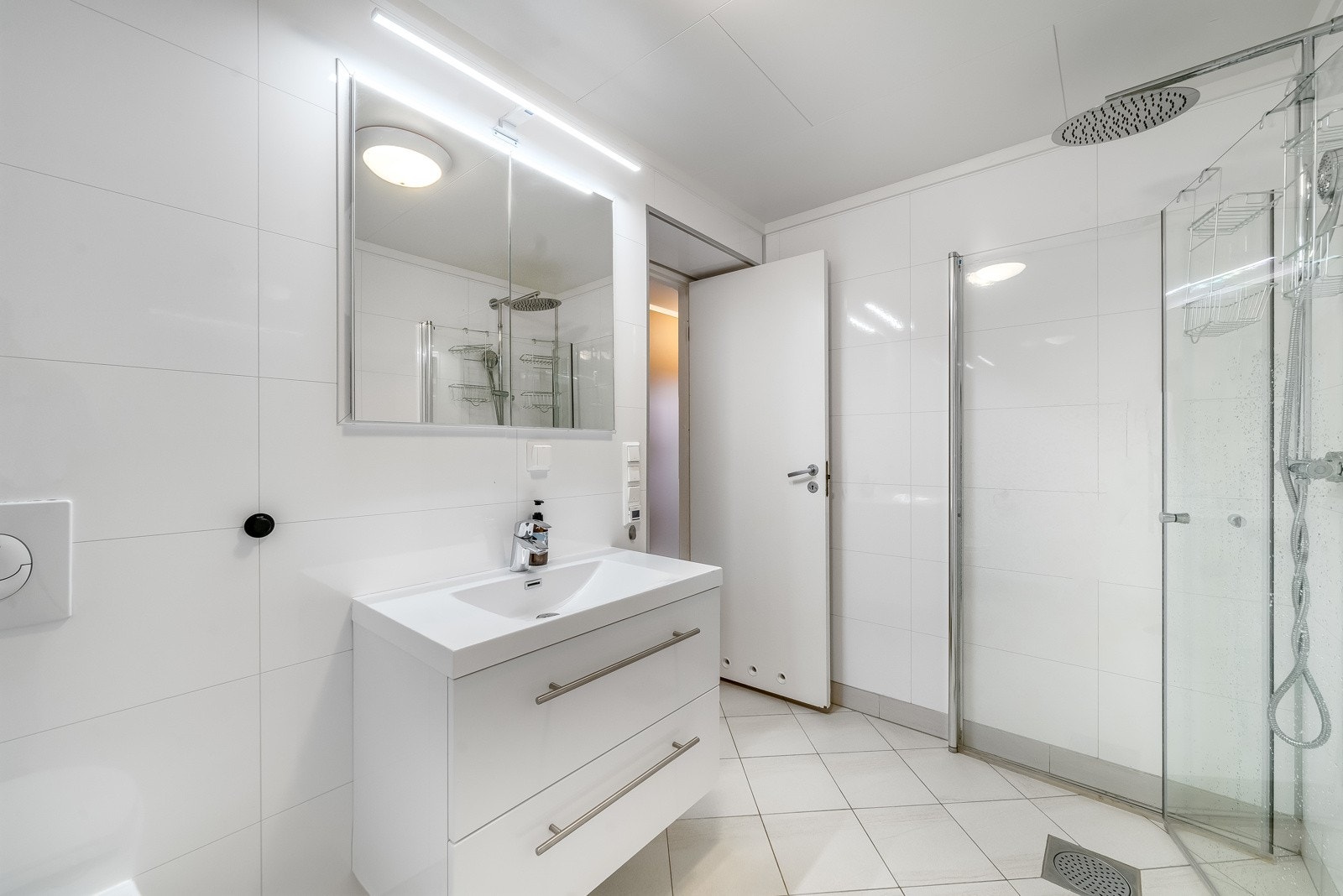 Pent bad med varmekabler i gulv. Fliselagt gulv og baderomsplater på vegg. Badet er innredet med baderomsinnredning, toalett og dusjløsning. Galleribilde