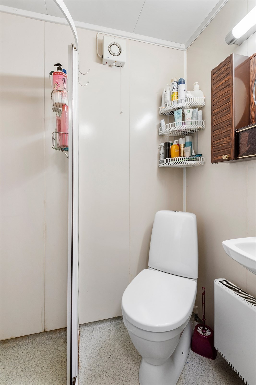 Badet er utstyrt med dusjnisje med blandebatteri og dusjhode, gulvmontert toalett og servant med ett-greps blandebatteri. Elektrisk styrt vifte ut via yttervegg. Galleribilde