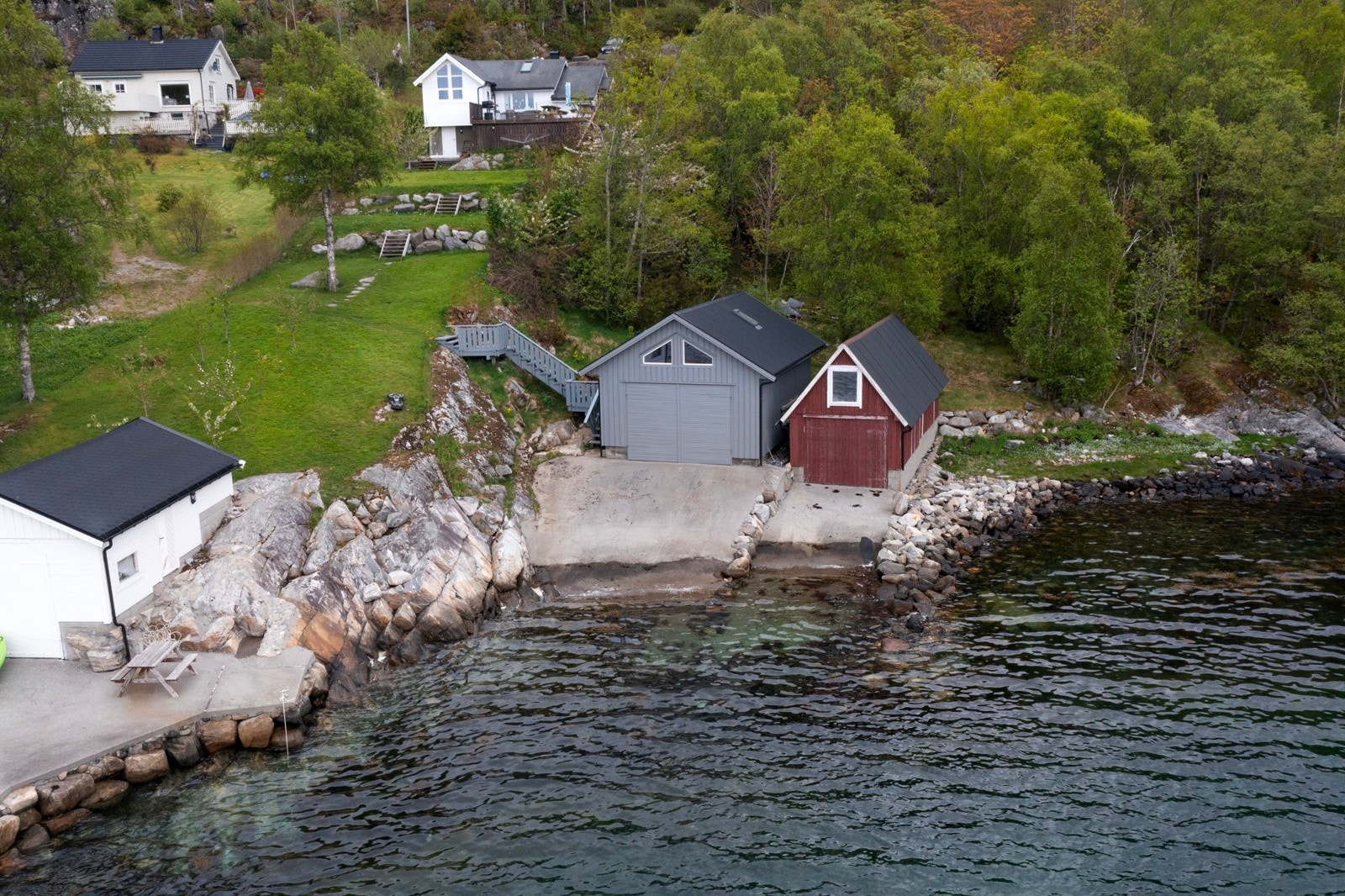 Yttertaket er tekket med lakkerte metallplater. Fasader har stående bordkledning. Galleribilde