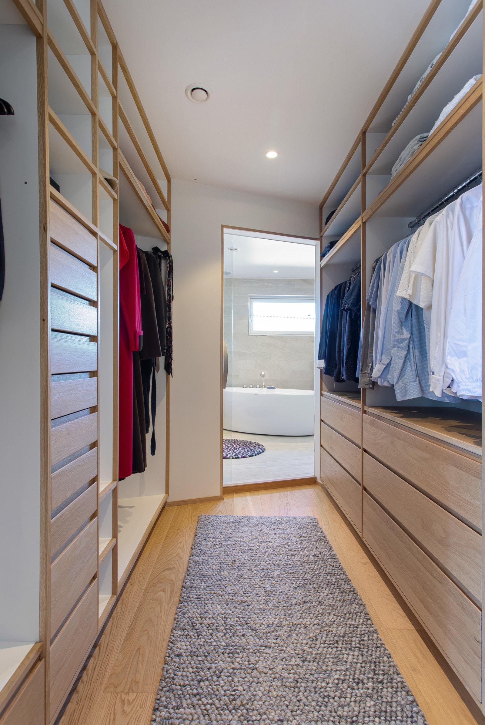 Walk-in-closet med plassbygget garderobe, innebygd safe og klessjakt til vaskerom. Galleribilde