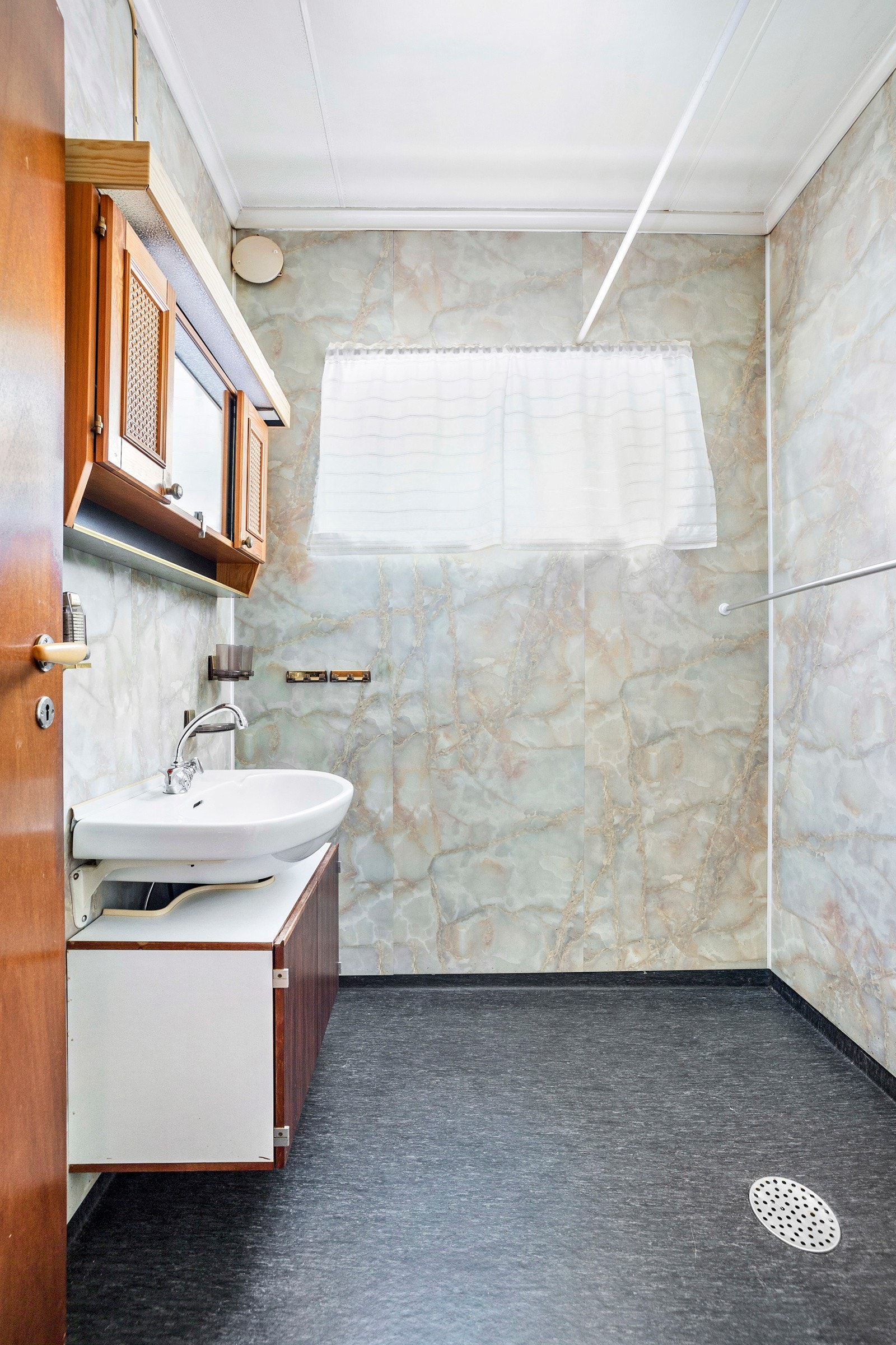 I første etasje har boligen et bad med åpent dusjhjørne. Badet er modent for modernisering. Galleribilde