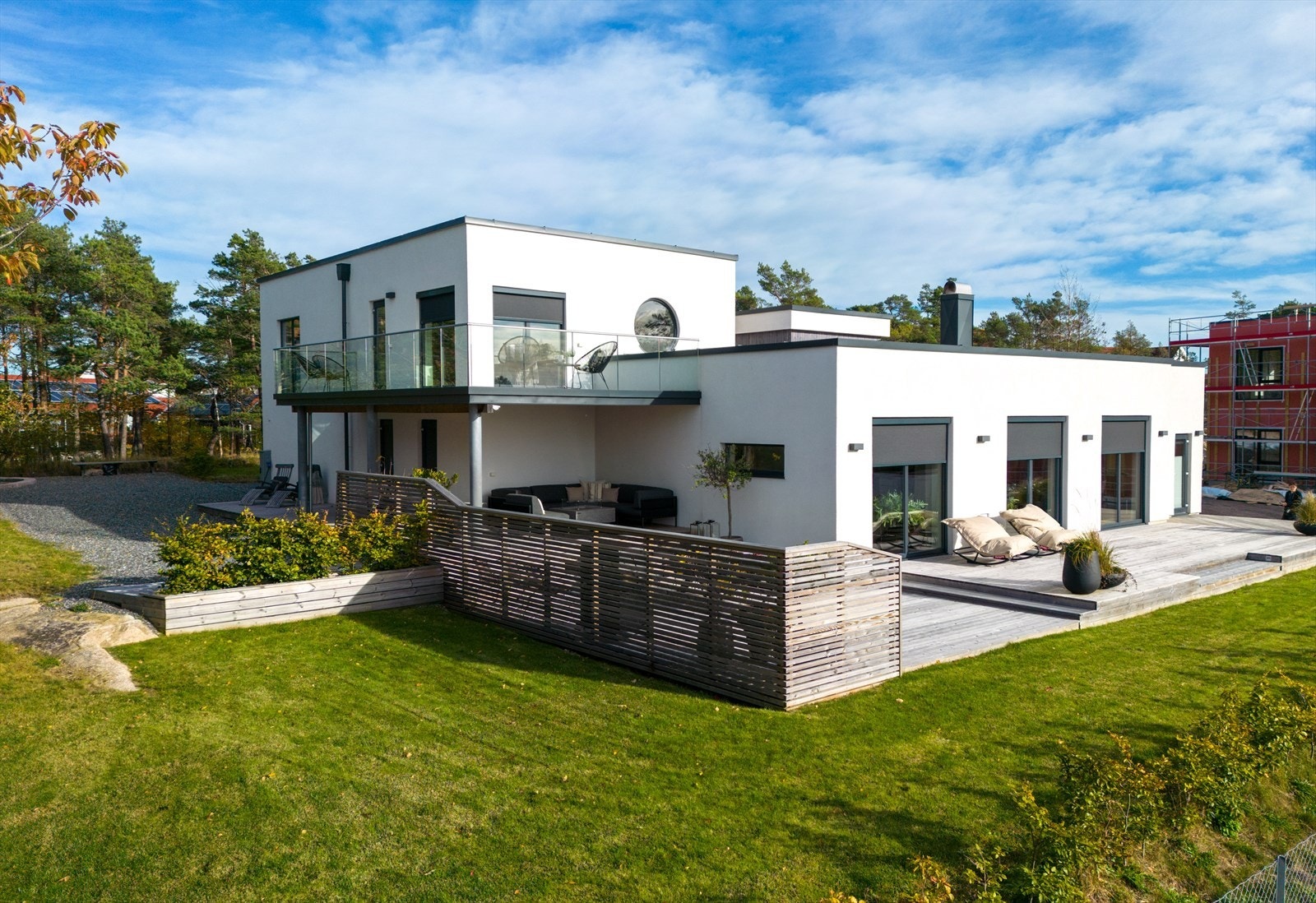 I boligens fremkant er en stor plen, med en hekkerad ned mot naboen. Galleribilde