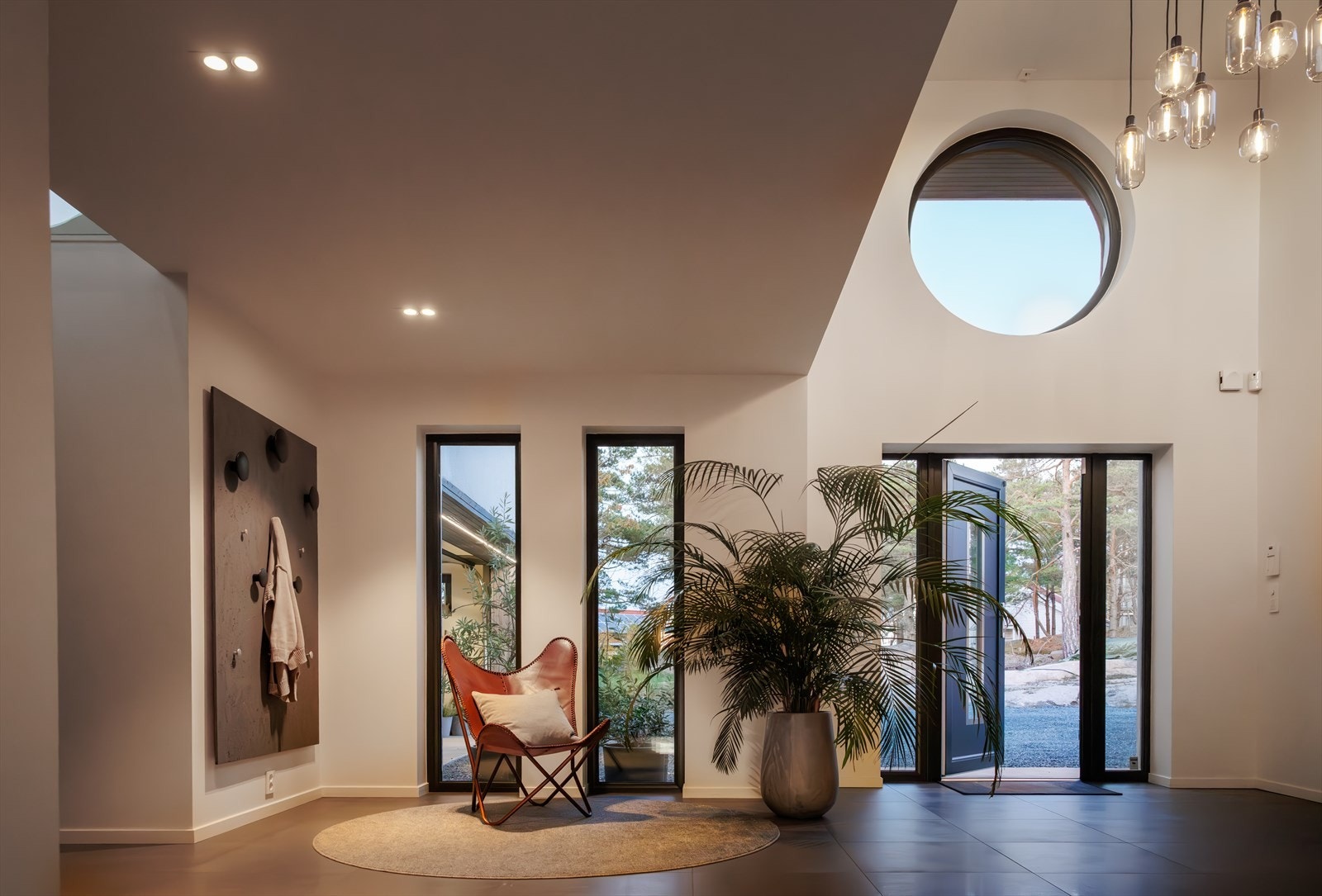 Hvite vegger, deilige store gulvfliser og en enorm takhøyde! Lyset slipper ned fra tre langstrakte og et rundt vindu - høyt oppe! Galleribilde