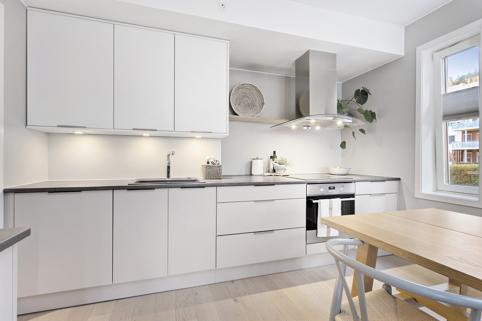 Kjøkkenet har innredning med glatte fronter. Benkeplaten er av laminat. Lys under overskap. Galleribilde