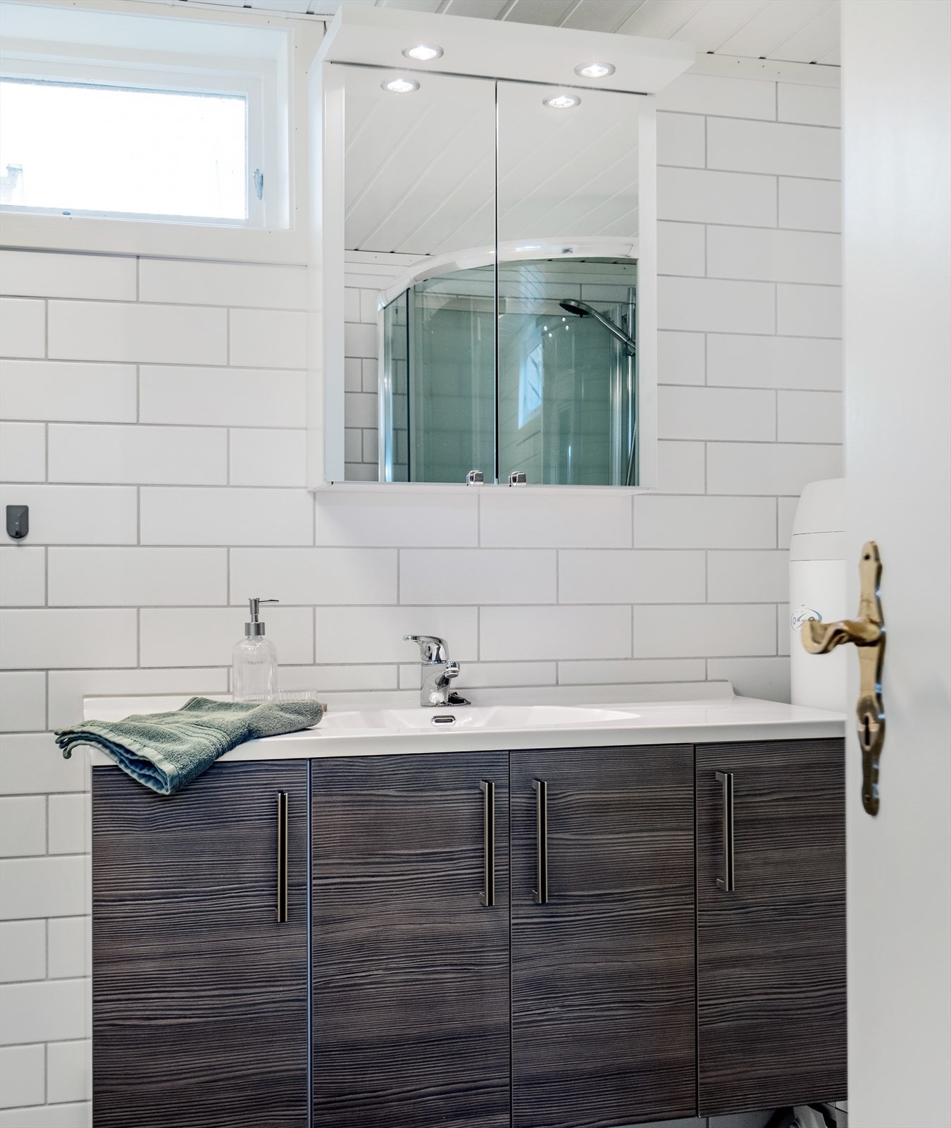 Badet i kjelleren er innredet med servant på innredning, dusjkabinett og toalett. Galleribilde