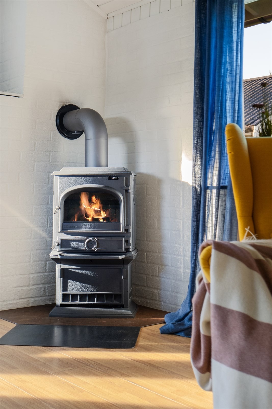 Oppvarming av stuen med blant annet vedfyring. Galleribilde