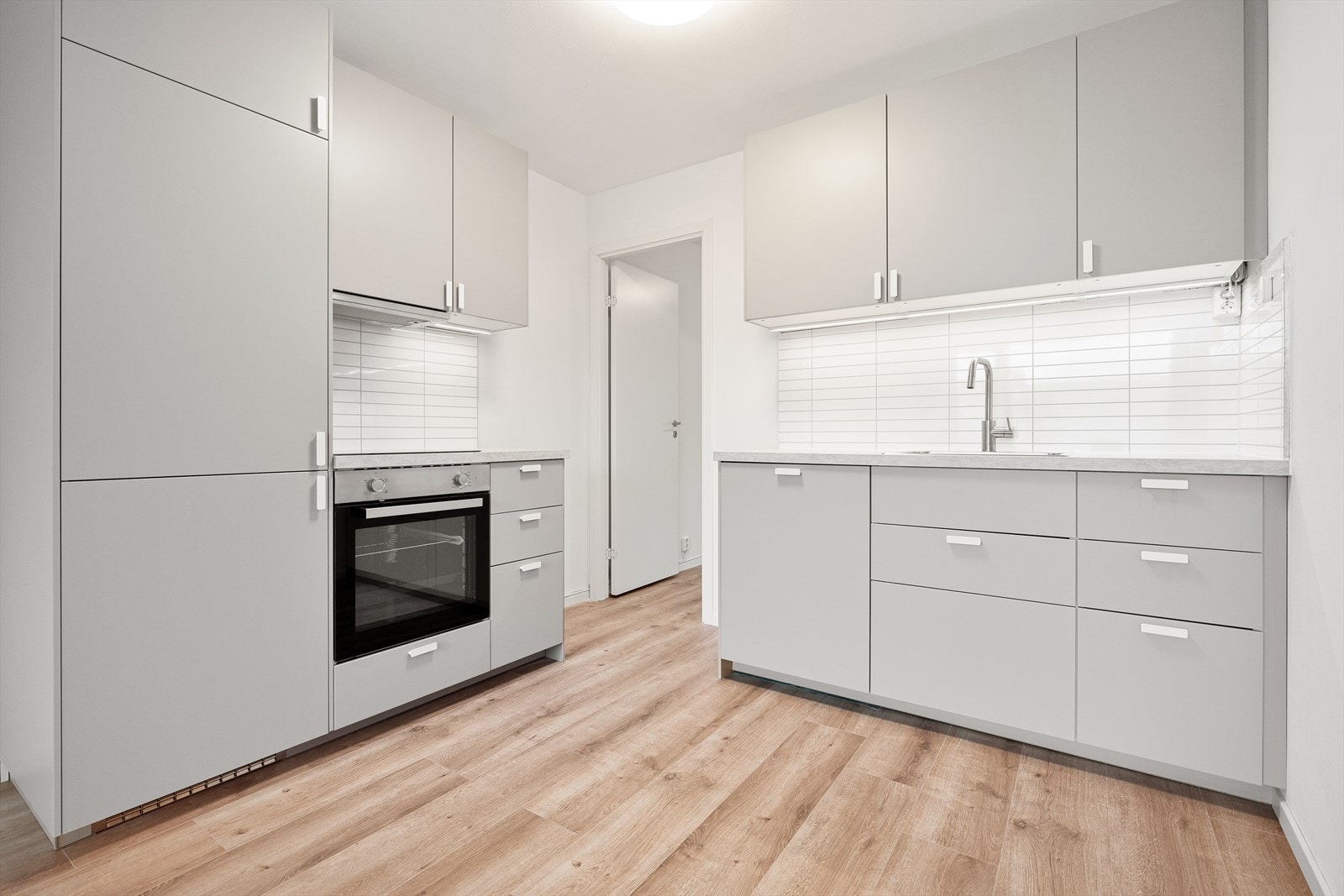 Delikat oppusset kjøkken med integrerte hvitevarer som kjøl/frys, komfyr, platetopp og oppvaskmaskin Galleribilde