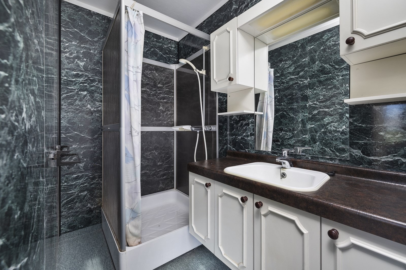 Badet er innredet med servant og dusjkabinett. Galleribilde