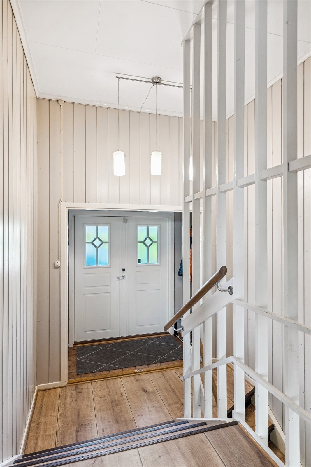 Velkommen inn - De få trinnene opp førere til boligens hovedetasjen, trappen ned fører til en innholdsrik kjelleretasje. Galleribilde