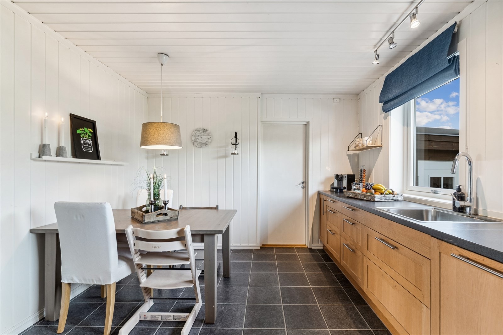 Kjøkkenet ble oppgradert i 2009 med eik innredning og lang benkeplate. Her er det gode oppbevaringsmuligheter. Bak døren er det en mellomgang som fører ut til garasjen. Her er det også lagringsplass. Galleribilde
