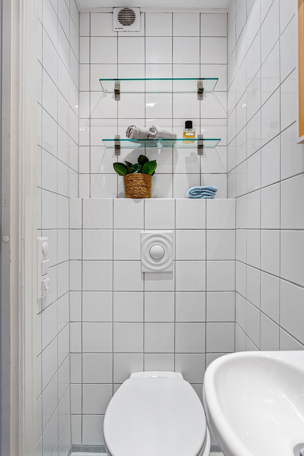 Badet er utstyrt med vegghengt wc, servant og dusj i hjørne. Det er flislagt gulv med elektriske varmekabler. Galleribilde