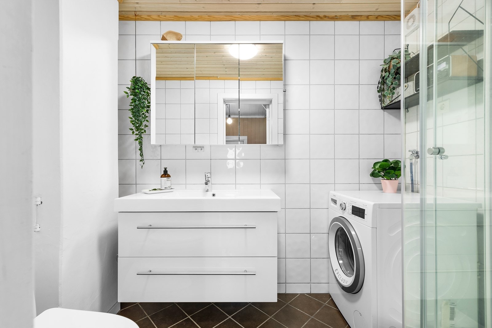 Badet er flislagt og har varmekabler i gulv. Rommet ble oppgradert med ny innredning (servant med underskuff og speilskap) i 2016. Galleribilde