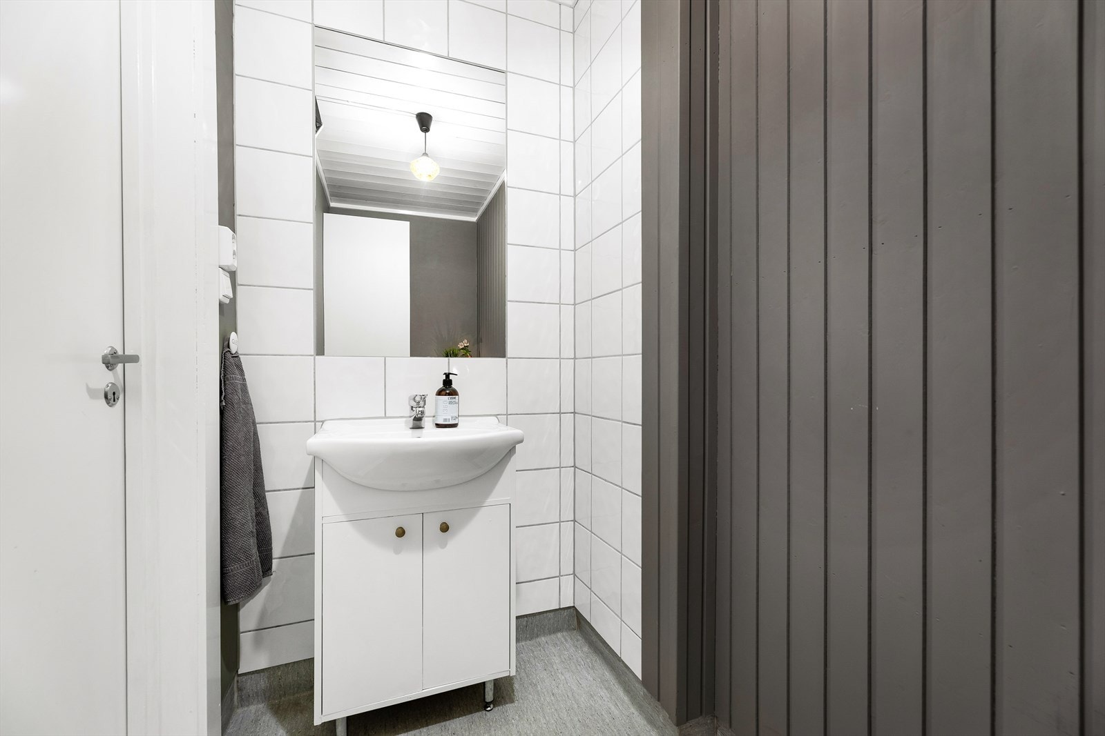 Toalettrommet har belegg på gulv og malt Fibo Trespo plater på vegger. Rommet inneholder servant, wc og innredning med skap. Galleribilde