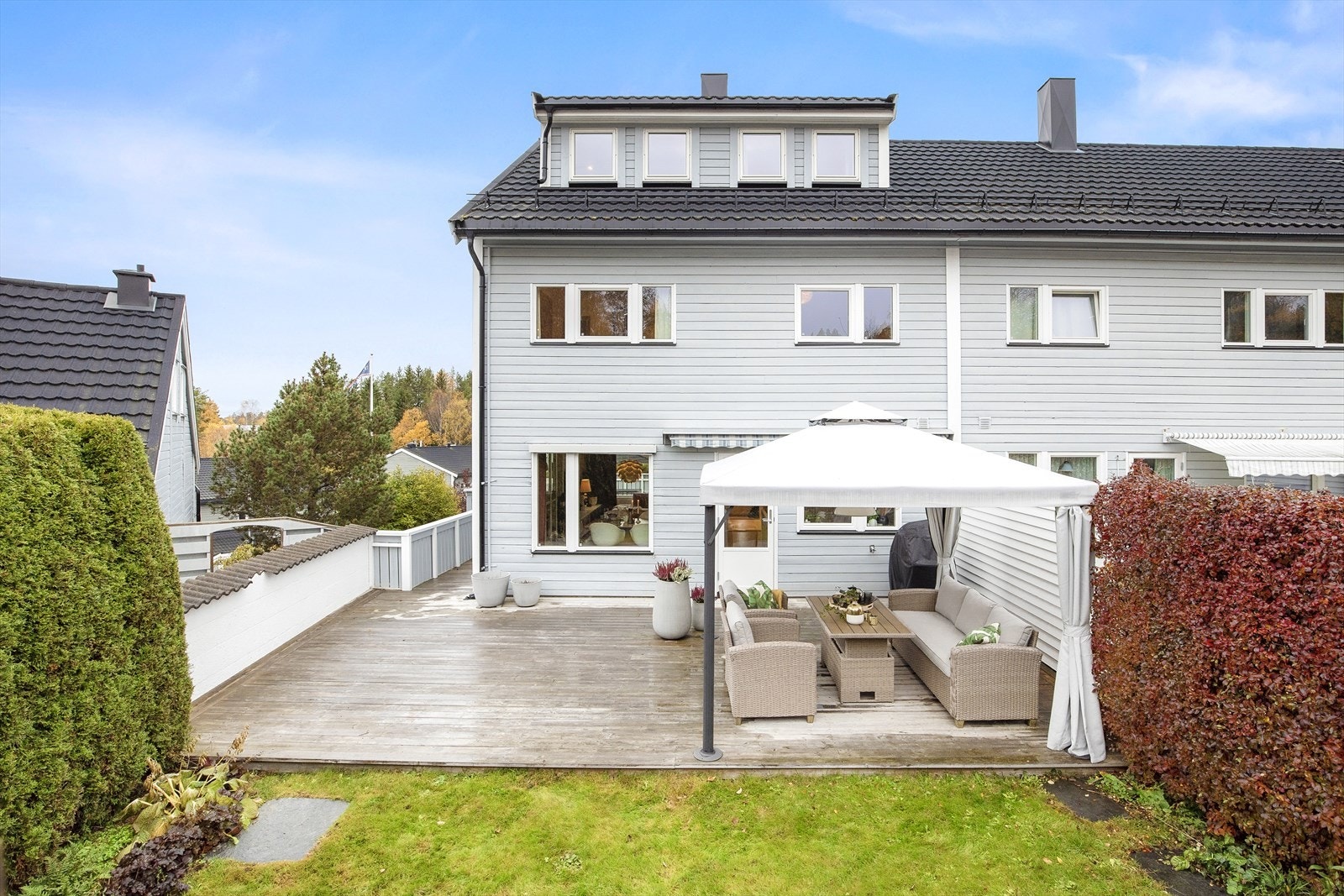 Pen opparbeidet hage med terrasse og plen, godt skjermet med levegg Galleribilde