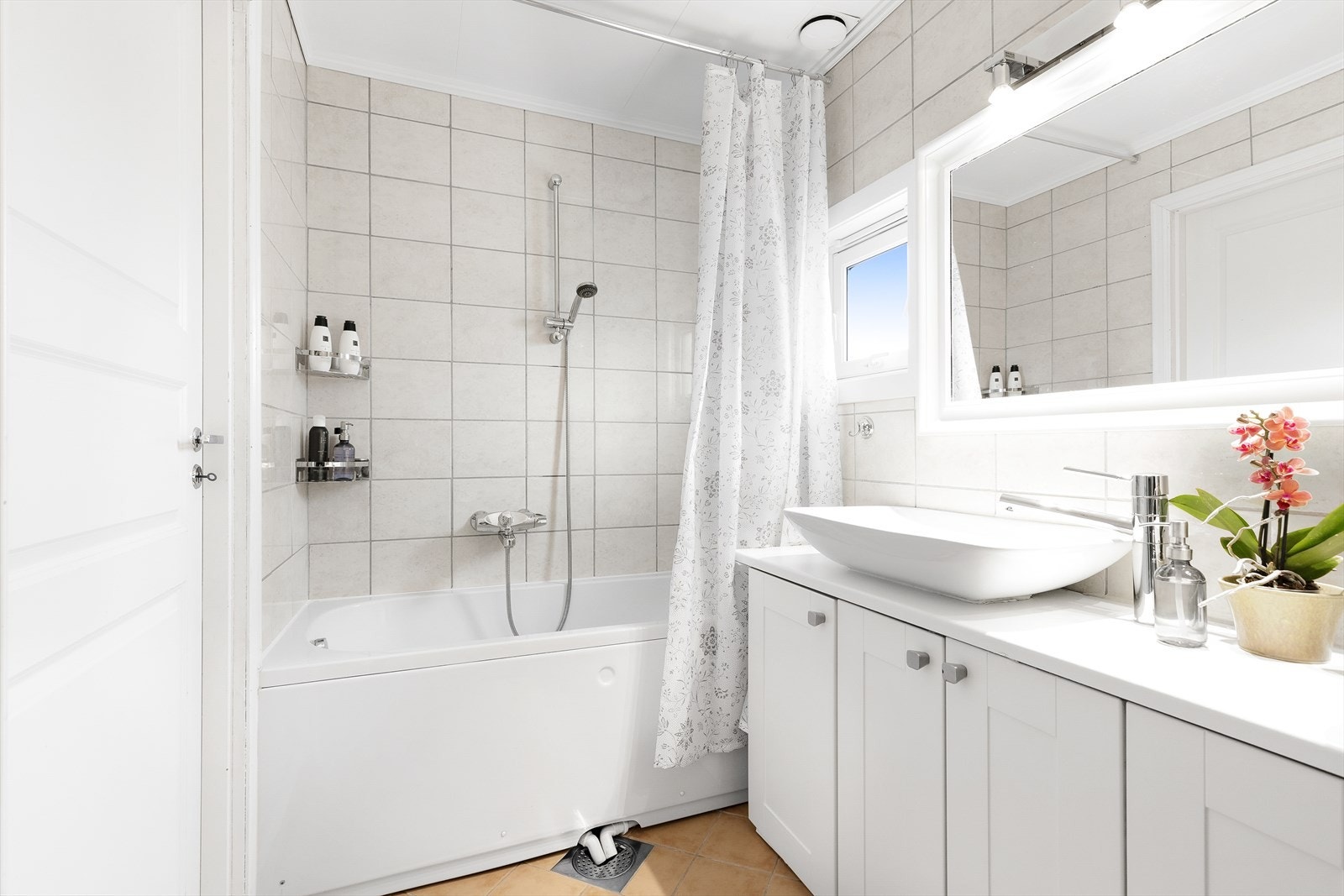 Badet har badekar med dusj, 2 servanter med skapinnredning og speil, samt opplegg til vaskermaskin og tørketrommel Galleribilde