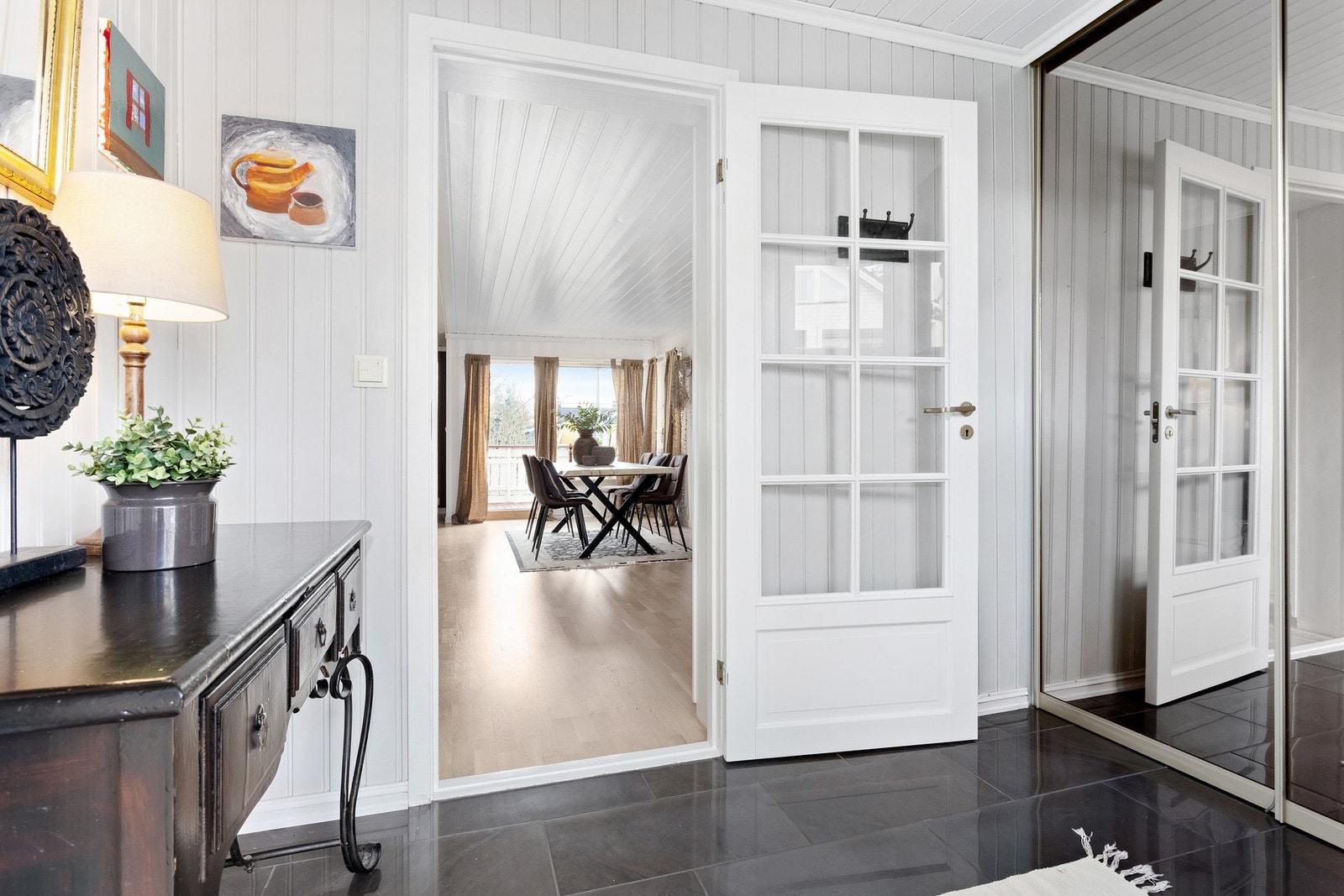 Innbydende gang med flislagt gulv og skyvedørsgarderobe med speilfront Galleribilde