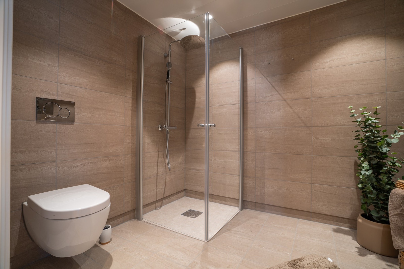 Vegghengt toalett og opplegg for både vaskemaskin og tørketrommel på badet. Galleribilde
