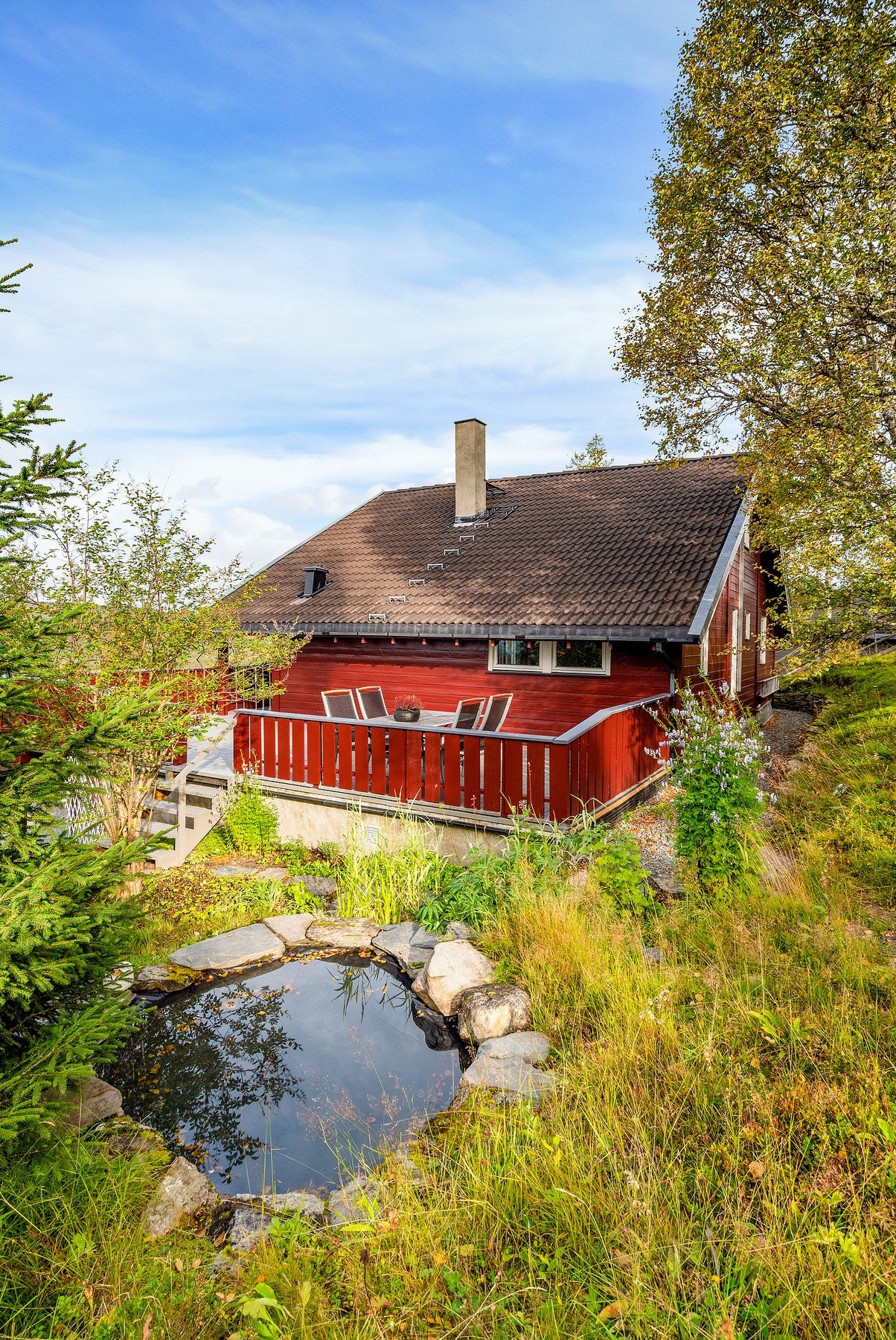 Tomten er pent opparbeidet med blant annet en fin dam. Galleribilde