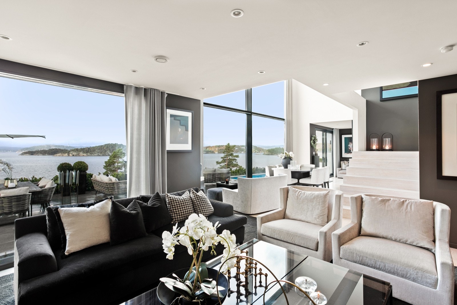 Store vindusflater som gir godt med lys inn i huset samt en nydelig sjøutsikt Galleribilde