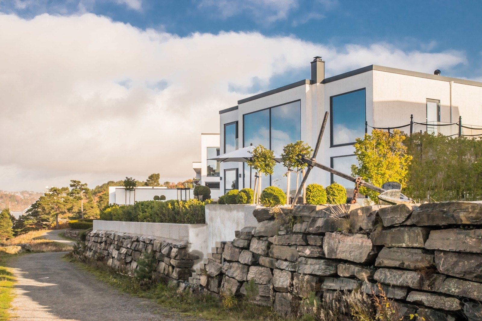 Fasade med trapp ned til sti som fører deg nedover mot felles badestrand Galleribilde