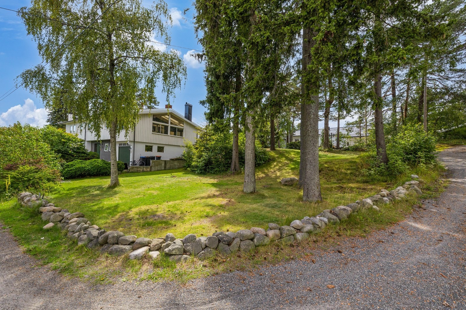 Tomten har en stor gressplen på nedsiden av huset med stort potensiale. Her sto det tidligere en garasje. Galleribilde