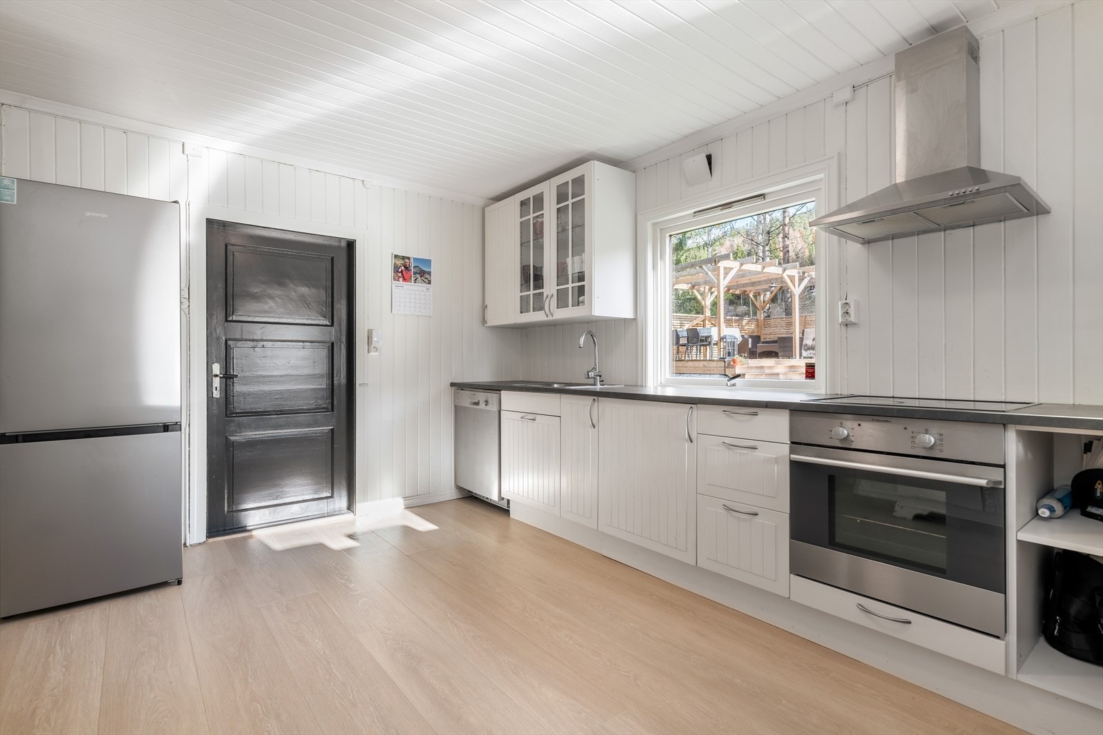 Kjøkkenet har en pen IKEA innredning med profilerte fronter og noe glasskap, samt laminat benkeplate fra 2021 med nedfelt vask. Galleribilde