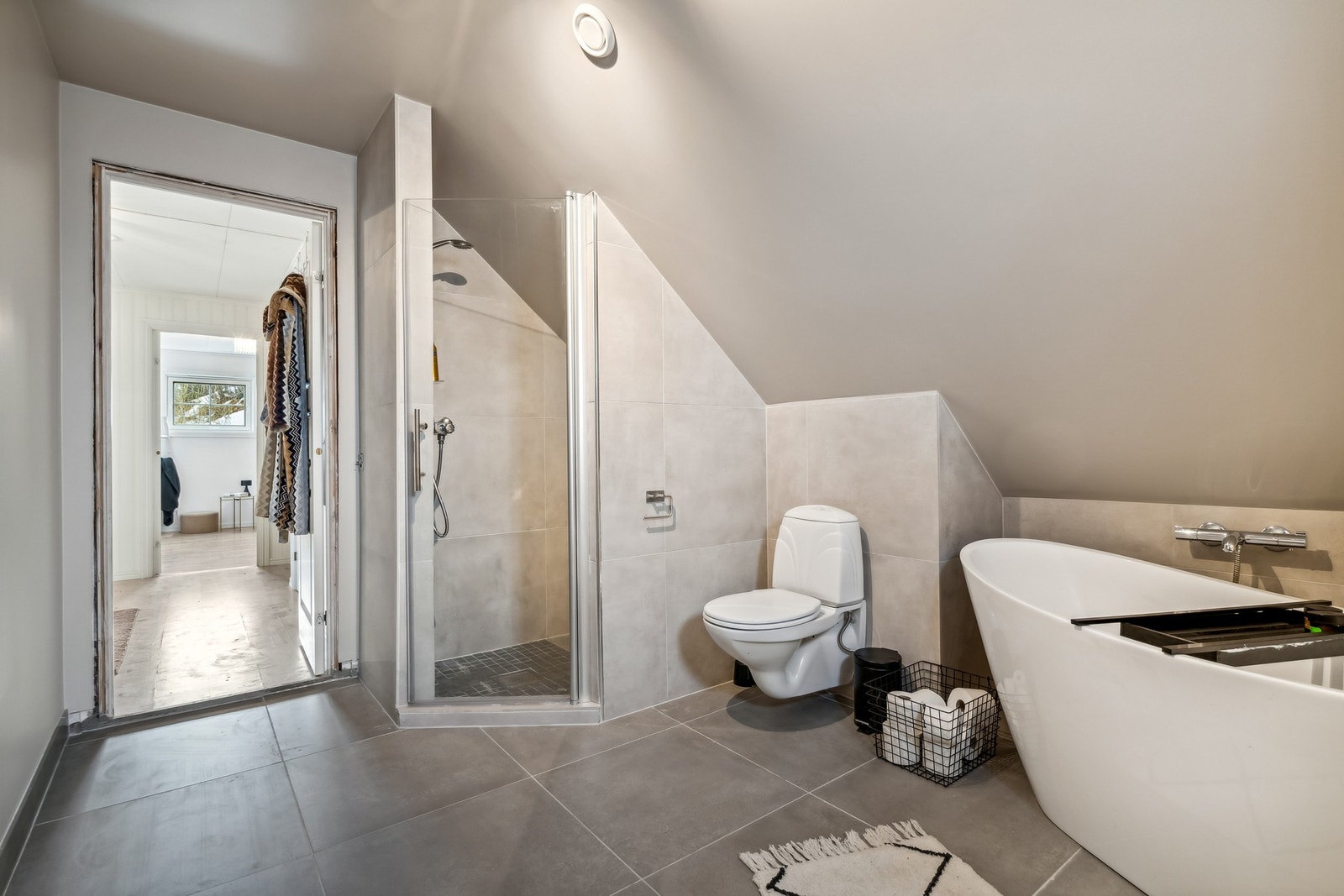 Badet er utstyrt med dusjnisje, vegghengt toalett og badekar Galleribilde