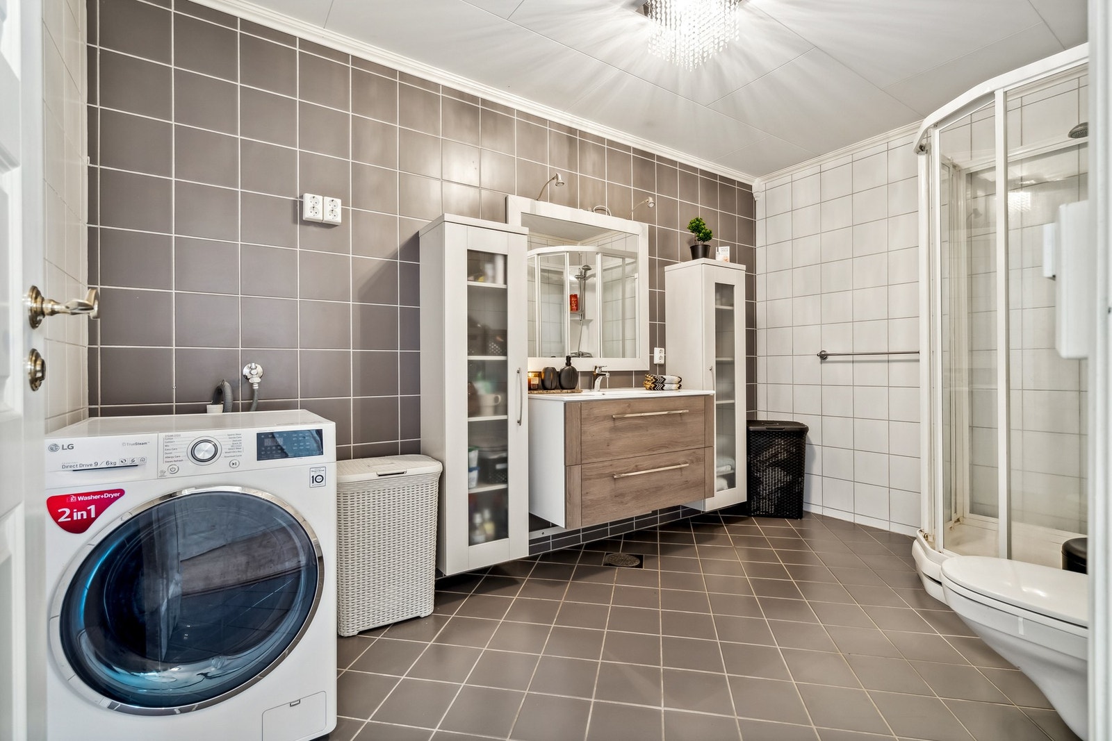 Badet består av dusjkabinett, baderomsinnredning, vegghengt toalett og opplegg for vaskemaskin/tørk Galleribilde