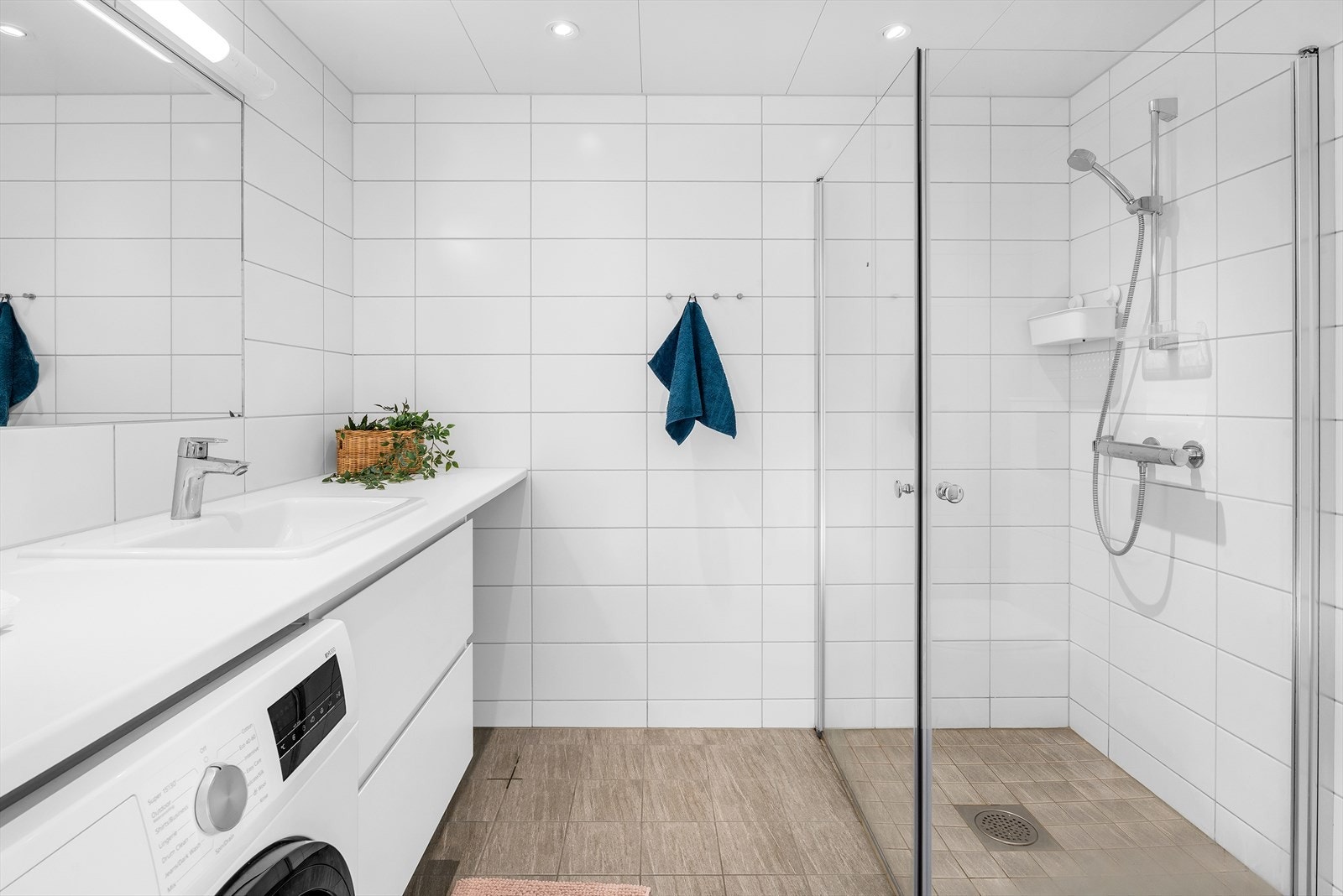 Badet er flislagt og har varme i gulvet. Det er opplegg for vaskemaskin. Galleribilde