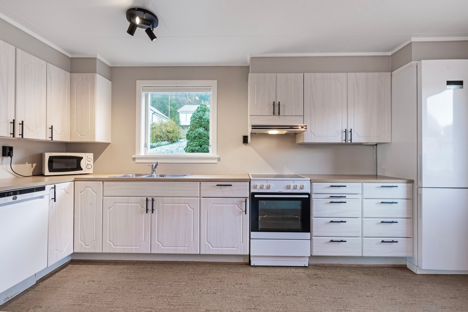 Kjøkken i hovedetasje har belegg på gulv og kjøkkeninnredning av ukjent alder. Innredningen har profilerte, folierte fronter og laminert benkeplate. Frittstående hvitevarer Galleribilde