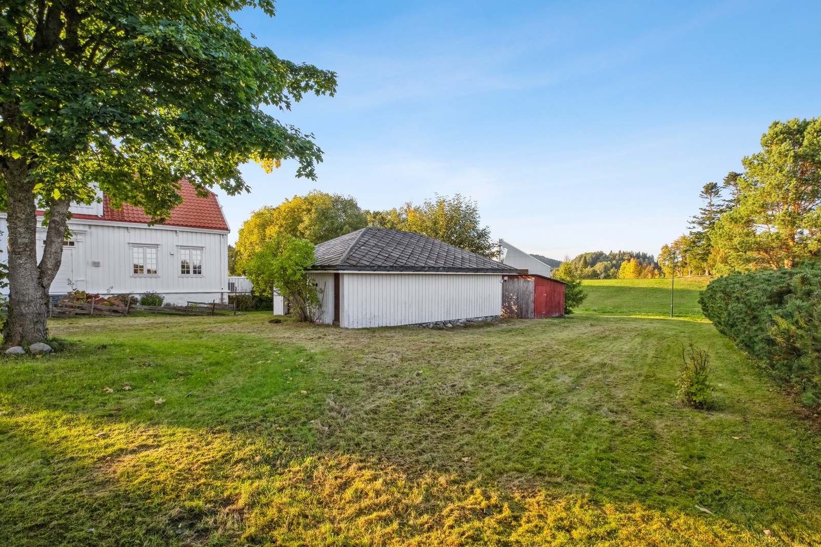 Tilhørende flat eiendomstomt som i dag er bebygd med to garasjer og en bod. Galleribilde