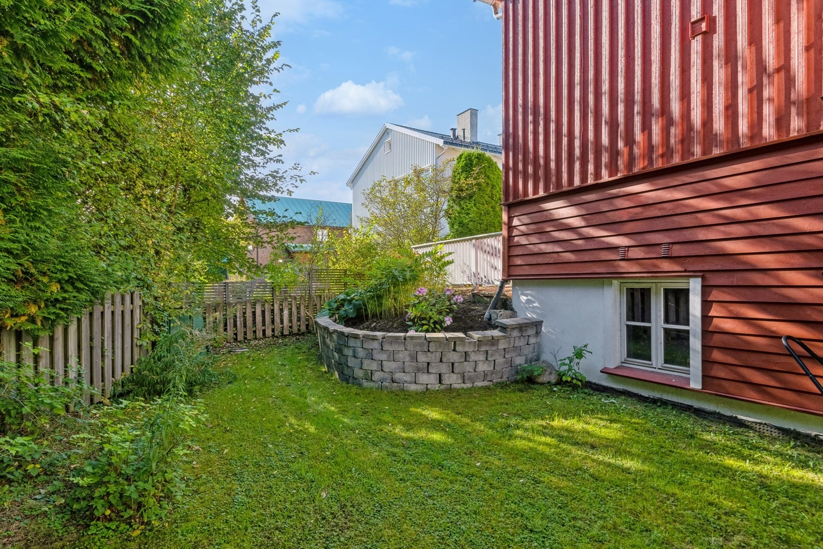 Tomten er pent opparbeidet med steinsatte gangstier, blomsterbed, støttemurer, trær og diverse beplantning. Galleribilde