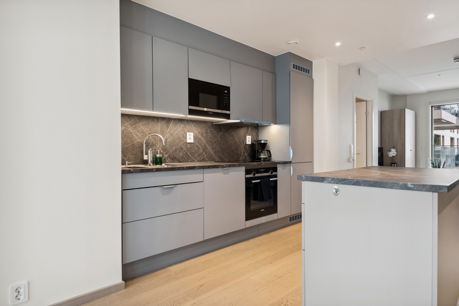 Kjøkkenet er rikelig utstyrt, har godt med arbeids- og oppbevaringsplass både i vegghengt innredning og i kjøkkenøy Galleribilde