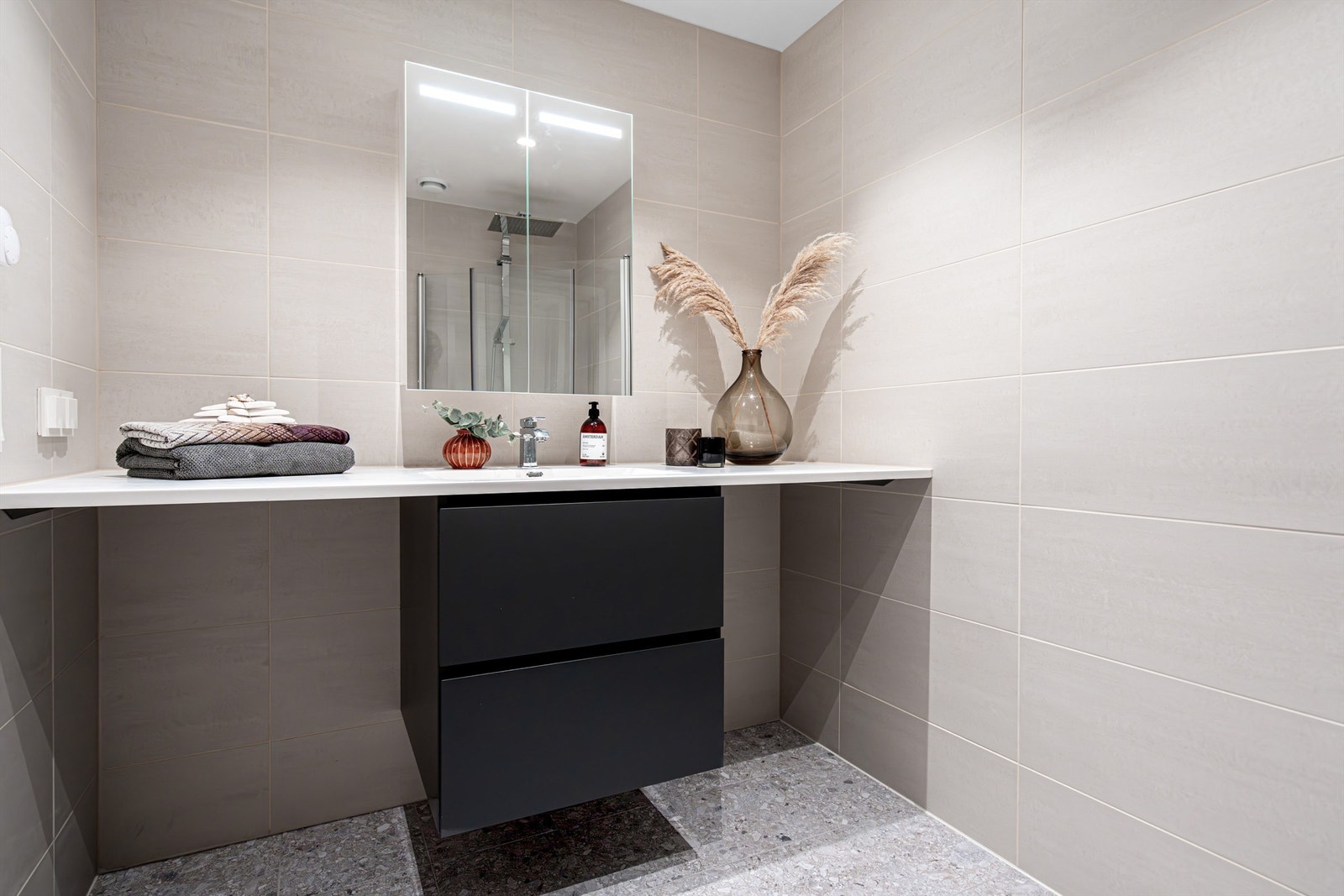 Leiligheten har et innbydende og oppgradert baderom på ca. 4,5 m². Speilskap med integrert lys. Servantskap med to grepsløse skuffer og servantarmatur fra Tapwell. Galleribilde