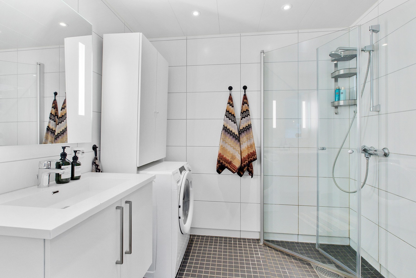 Pent flislagt bad av god størrelse og ekstra oppbevaringsplass, samt opplegg for vaskemaskin. Takstmann har gitt tilstandsgrad 0 og 1 på alle undersøkte punkter på badet Galleribilde