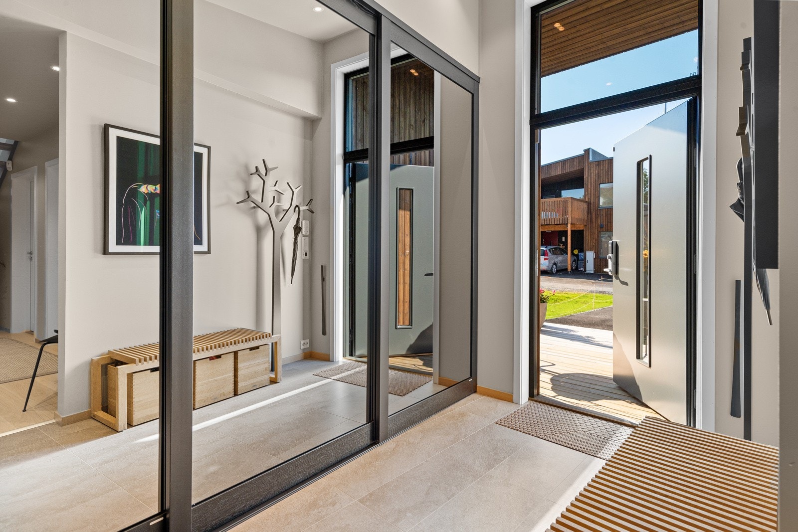 Velkommen inn! Entréen har måltilpassede skyvedører fra Langlo med speil og Elfa garderobeinnredning. Galleribilde