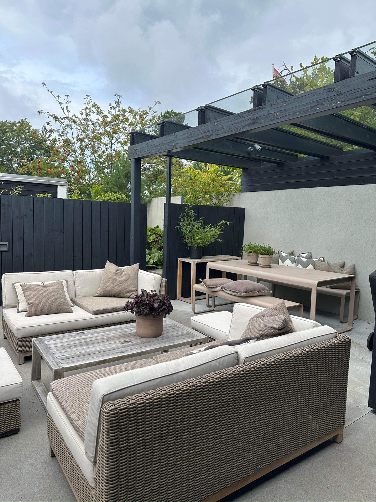 Solrik og usjenert uteplass på siden av huset med pergola med tak Galleribilde