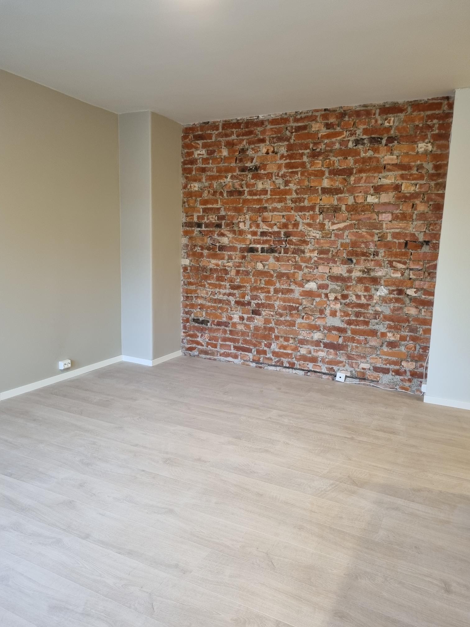 Flott teglsteinsvegg som gir stuen et særpreg Galleribilde
