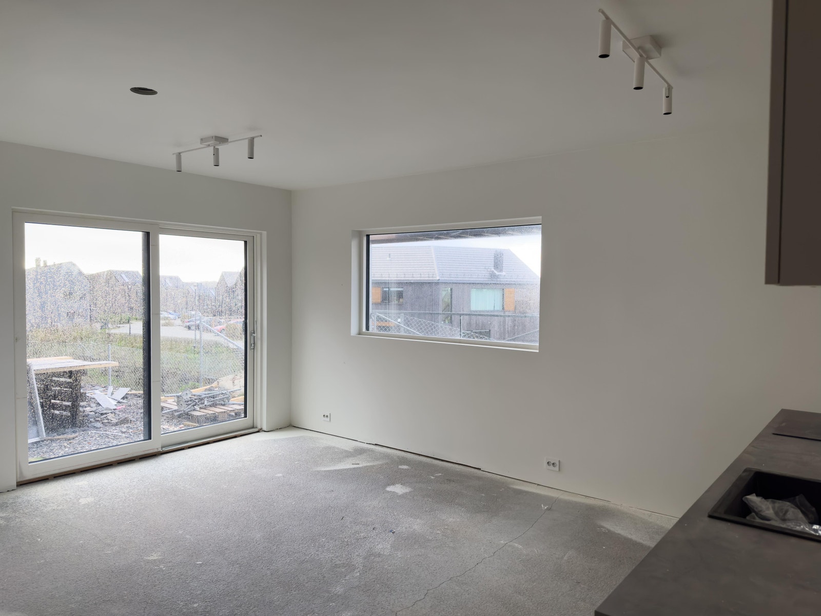 Stuen, sett fra kjøkkenet. Egen skyvedør til privat uteområde hvor det er sol hele dagen. Snart er det klart for å legge gulv også her. Galleribilde