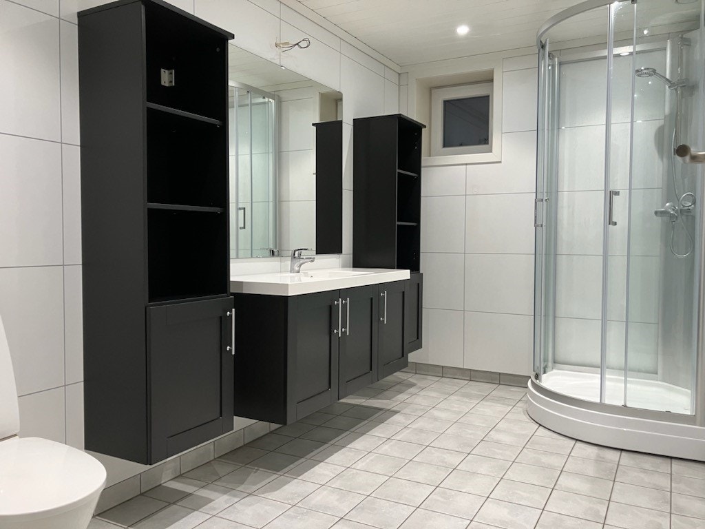 Moderne og romlig baderom som inneholder baderomsinnredning, dusjkabinett og toalett. Baderommet har varmekabler i gulv. Galleribilde