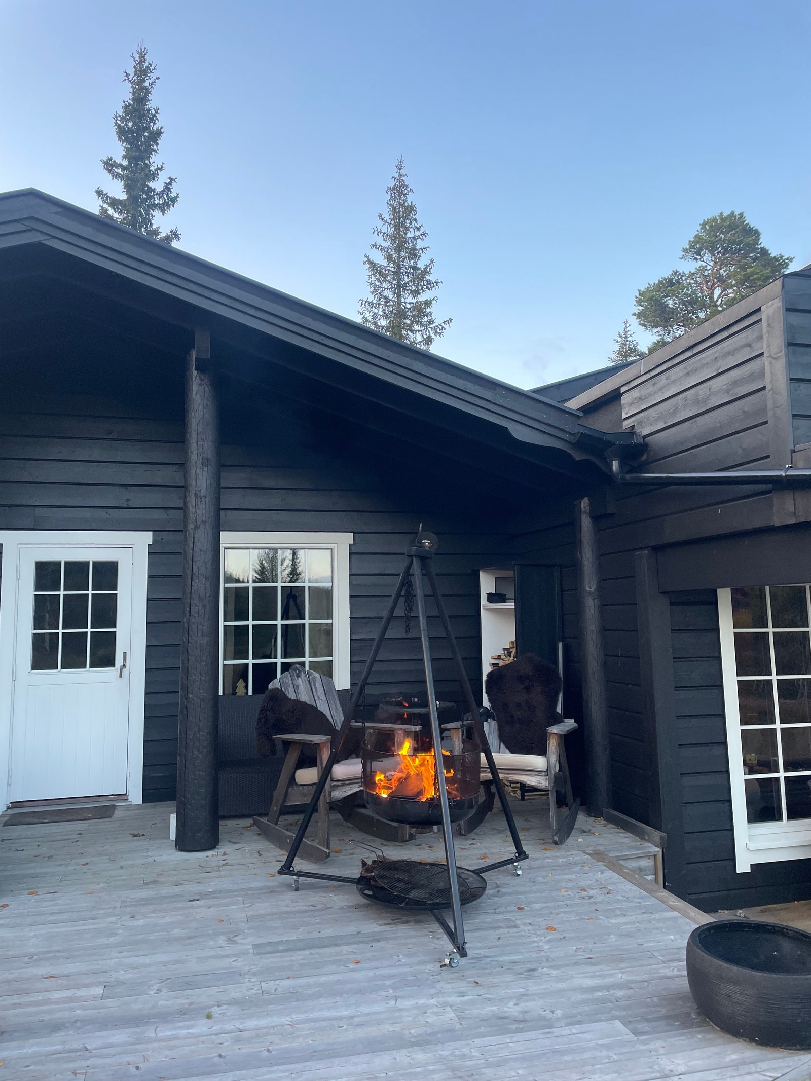 Uteplassen med bålpanne, stort bord med sitteplasser, gyngestoler. Jaccuzi Galleribilde