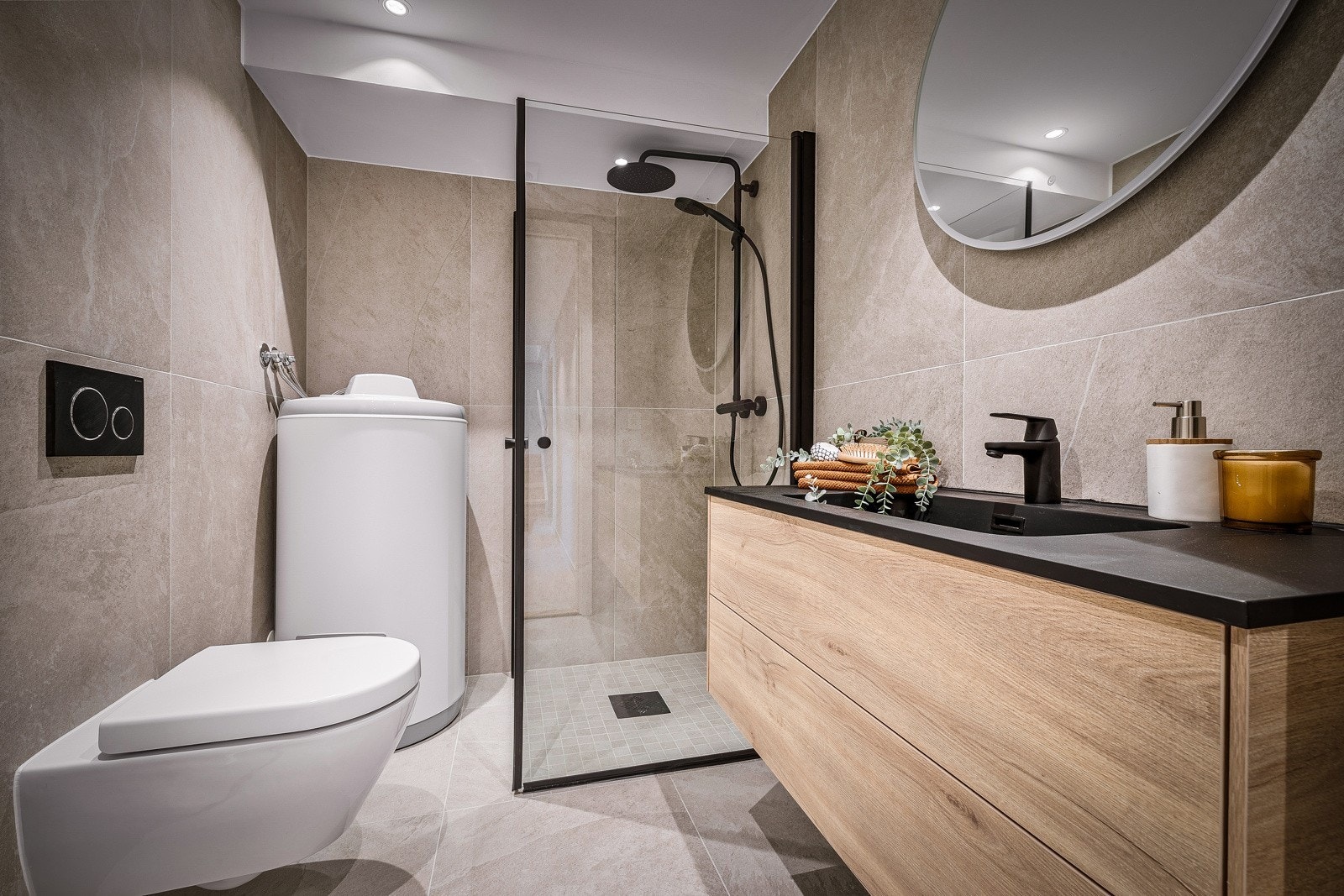 Badet er pent helfliset og er utstyrt med benkeskap, vegghengt toalett og et romslig dusjhjørne med regnfallsdusj. - måler 4kvm Galleribilde