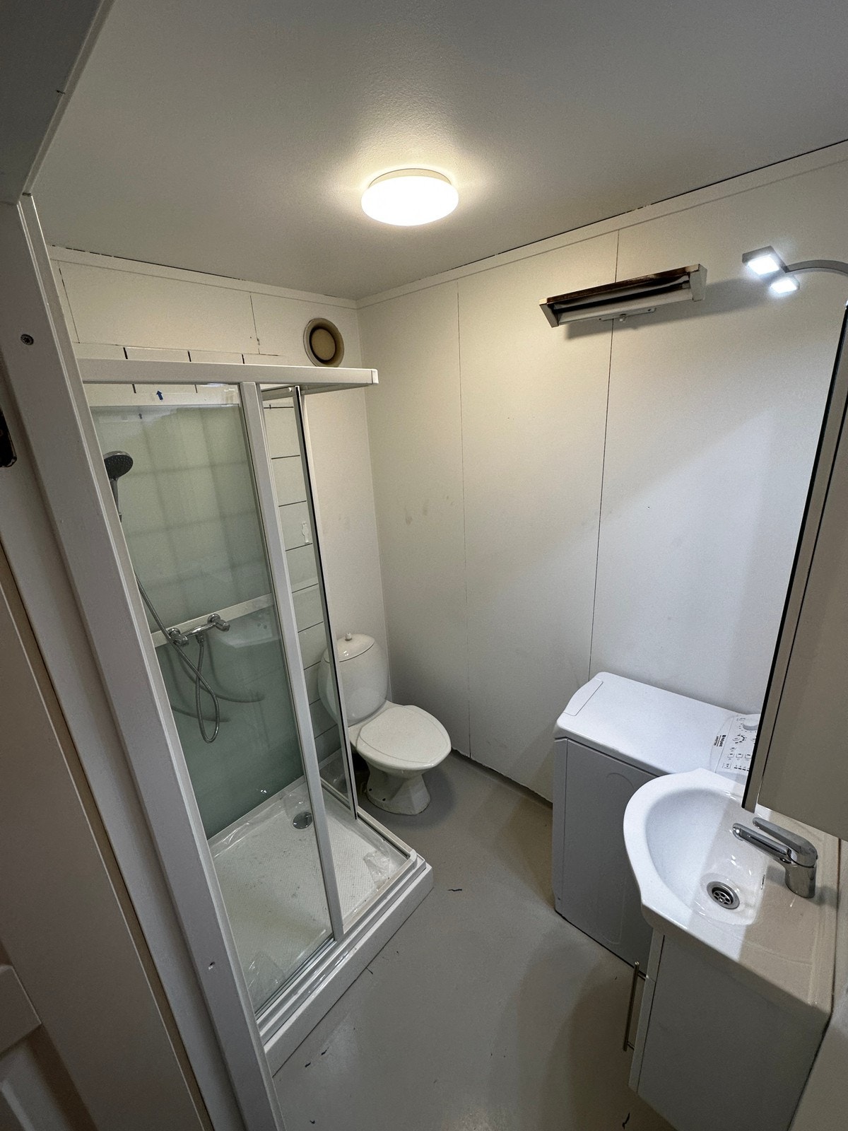 Badet blir relativt likt som dette med dusjkabinett og vaskemaskin Galleribilde