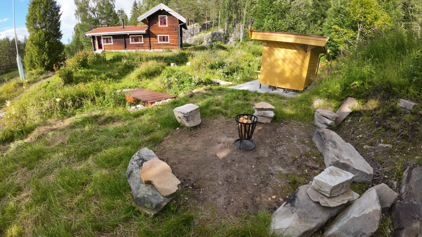 Det er bålplass i hagen med store sittesteiner funnet på tomta. Galleribilde