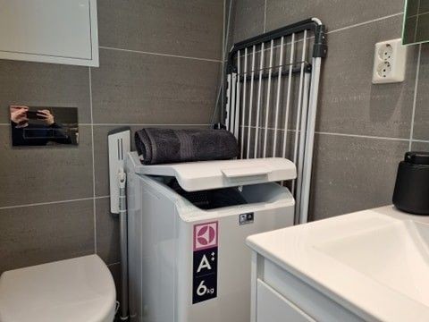 Lyst bad med toalett, servantskap og dusj. Vaskemaskin følger også med. Galleribilde