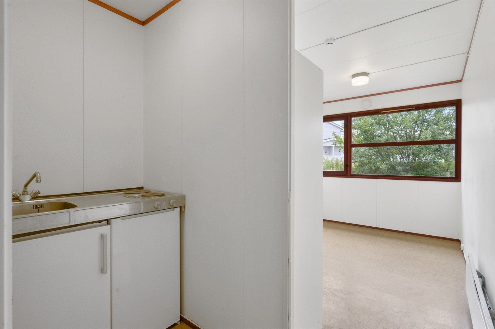 Kjøkkenkrok med to koketopper og kjøleskap under benk Galleribilde