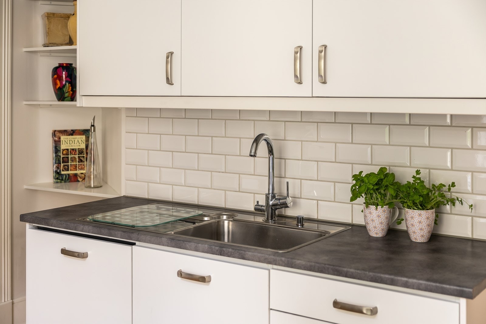 Smakfulle detaljer som håndtak og armatur i krom og fliser på vegg Galleribilde