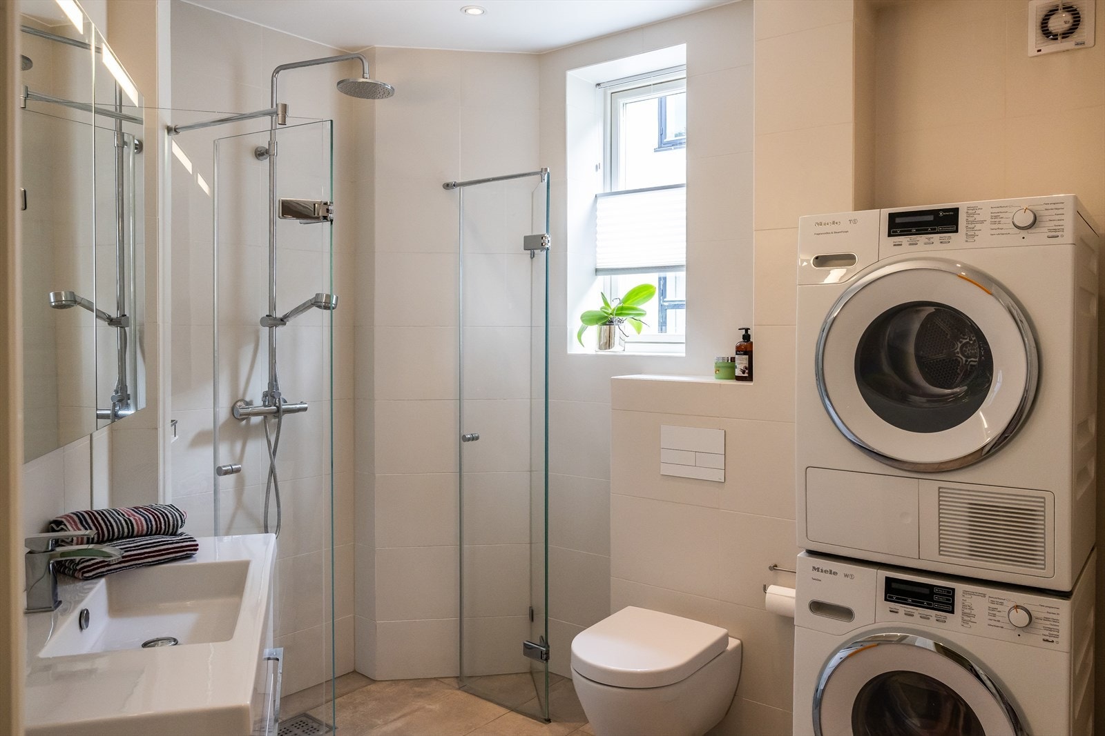 Moderne baderom (fra 2013) med flislagt gulv og vegger, spotbelysning og varmekabler i gulv Galleribilde