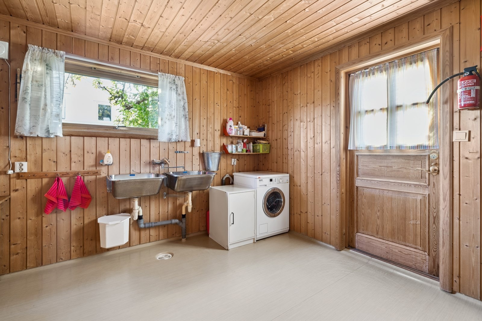 Stort og praktisk vaskerom med 2 utslagsvasker og opplegg for vaskemaskin. I tillegg er det dusj og utgang til terrasse/hage. Galleribilde